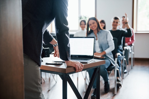 L'homme a une question La main levée Groupe de personnes à une conférence d'affaires dans une salle de classe moderne à la journée